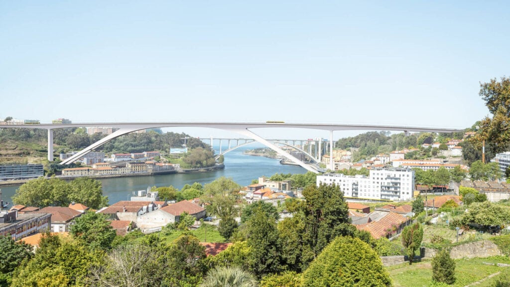 Eine moderne weiße Brücke, die einen Fluss überspannt, mit Häusern und Bäumen an den Ufern unter einem klaren Himmel.